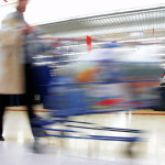 Woman with cart in motion at the grocery store.